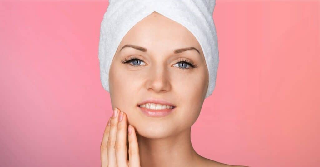 Woman with towel touching face